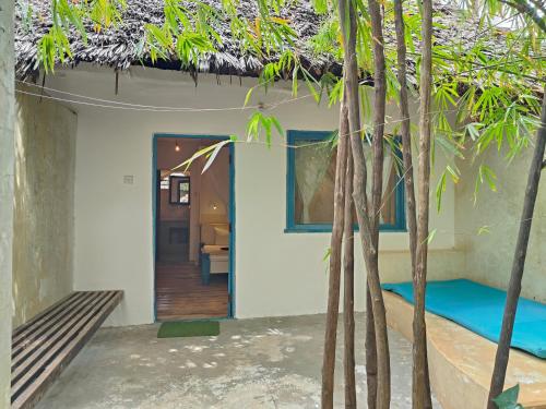 a room with a bed and a room with trees at Paje By Night Bungalows in Paje