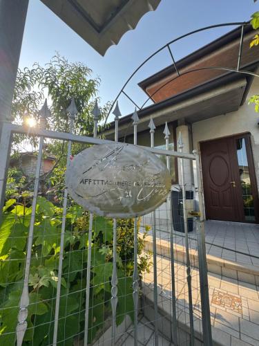 a sign on a gate in front of a house at B&B Orio Affittacamere Foresteria Lombarda in Grassobbio