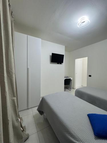 a bedroom with two beds and a tv on the wall at B&B Orio Affittacamere Foresteria Lombarda in Grassobbio