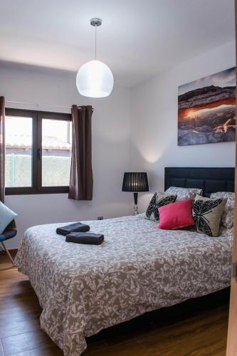 a bedroom with a large bed with pillows on it at Villa Romans in Caleta De Fuste