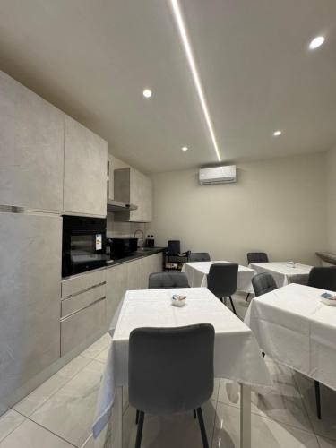 a room with tables and chairs and a kitchen at B&B Orio Affittacamere Foresteria Lombarda in Grassobbio