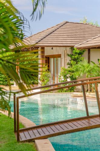 a swimming pool in front of a house at AWARA POUSADA BOUTIQUE in São Miguel do Gostoso