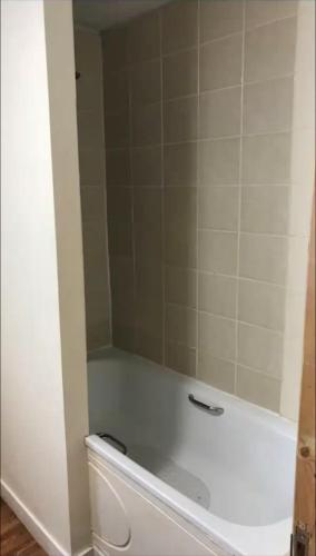 a bath tub with a mirror on top of it at 284 - Room 5 - Beachfront - Fantastic sea views in Swansea