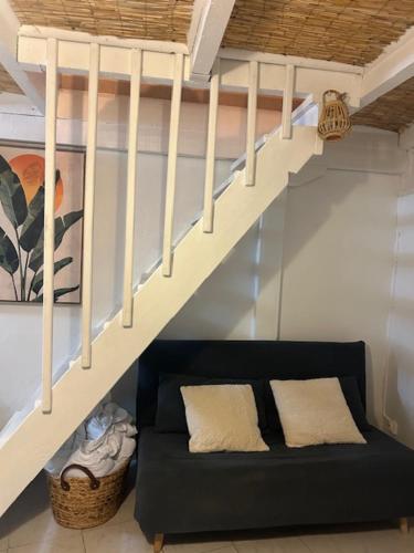 a black couch sitting under a stair case at Duplex Le Nusa in Perpignan