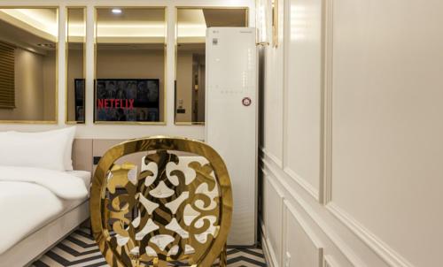a room with a chair and a bed in it at Hotel 99 Prestige in Seoul