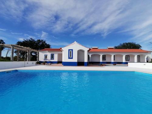 a villa with a swimming pool in front of a house at Monte Cores do Vale - Villa com piscina privada in Montemor-o-Novo
