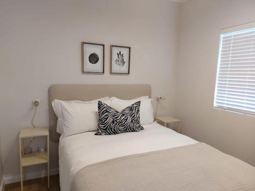 a bedroom with a bed with a zebra pillow on it at 211 The Meadows in George