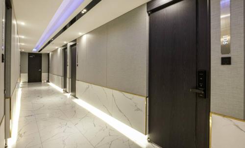 a hallway in a building with doors and a tile floor at Hotel 99 Prestige in Seoul