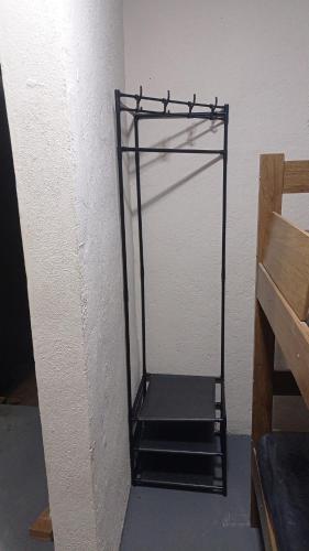 a metal shelf in the corner of a room at Juquitiba Chácara Recanto dos Magos Chalé Piscina Fogão a Lenha Churrasqueira in Juquitiba