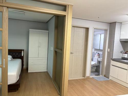 une petite chambre avec un lit et une cuisine dans l'établissement Marina Residence Hotel, à Busan