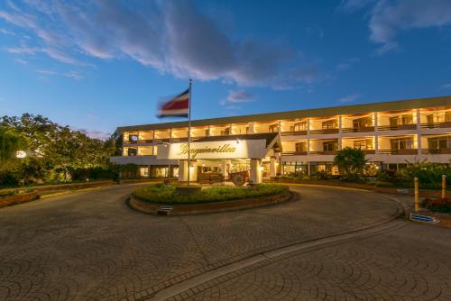 a hotel building with a flag in front of it at Hotel Bougainvillea San José in Santo Domingo