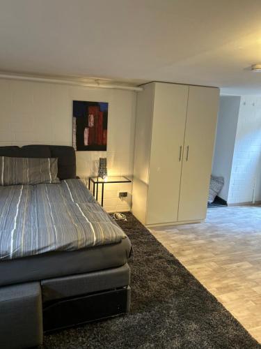 a bedroom with a bed and a white cabinet at Ruhige 1 Zimmerwohnung Souterrain in Bortfeld