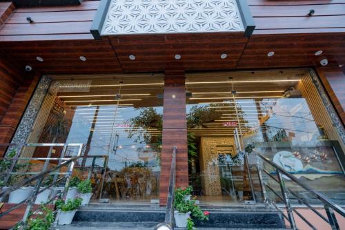 a store front with a glass door with plants at Hotel Relax Inn Ganga Rishikesh in Rishīkesh