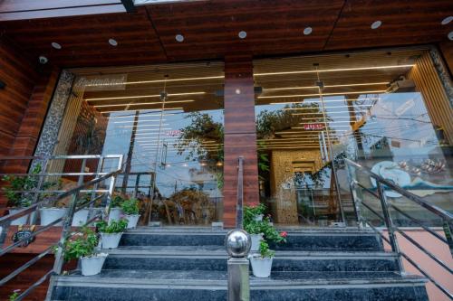 a store front with stairs and potted plants at Hotel Relax Inn Ganga Rishikesh in Rishīkesh