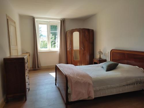 a bedroom with a bed and a dresser and a window at Maison de village in Juvigny-sur-Loison