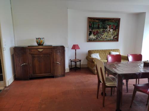 a living room with a table and a couch at Maison de village in Juvigny-sur-Loison