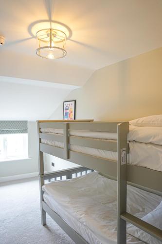 a bedroom with two bunk beds and a chandelier at The Clarence Gardens Hotel, BW Signature Collection in Scarborough