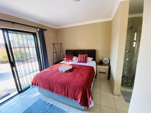 a bedroom with a bed and a glass shower at Lesari Stay in Centurion