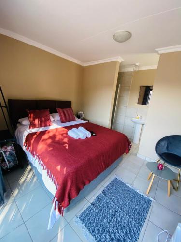 a bedroom with a large bed with a red blanket at Lesari Stay in Centurion
