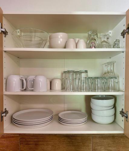 a cupboard filled with plates and bowls and dishes at Apartment Tatry Comfort - Tatranská Lomnica in Vysoké Tatry
