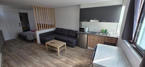 Una pequeña sala de estar con un sofá y una cocina. en El rincon, en Cambados