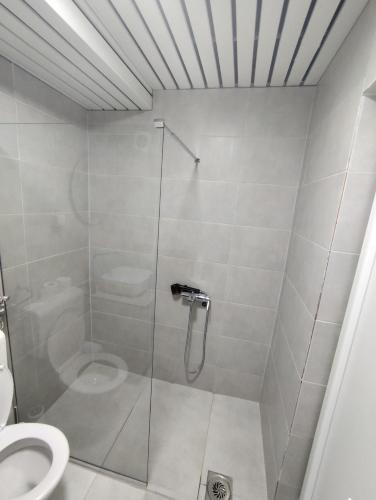 a bathroom with a shower and a toilet at Gigabit High-Speed Internet Modern Apartment in Skopje
