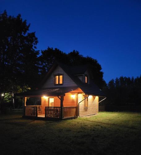 a small house lit up at night with lights at Przystań Frącki in Prącki