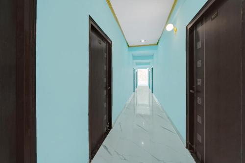 a hallway with two black doors and a blue ceiling at Super Hotel O R K Marriage Hall and Guest House in Patna