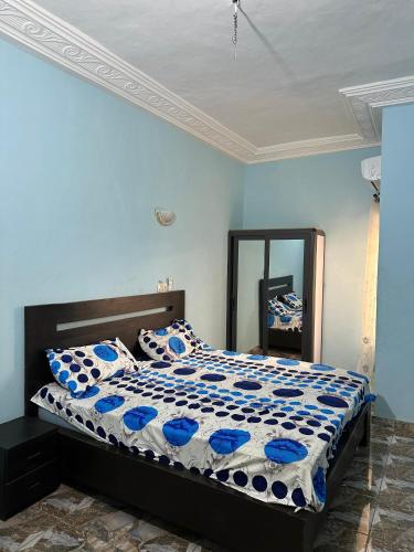 a bedroom with a bed with blue walls and a mirror at ADISSA's PLACE in Cotonou