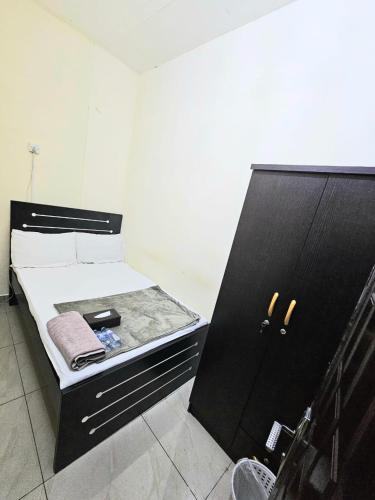 a small bed with a black cabinet in a room at DraGon Executive Homes 002 in Dubai