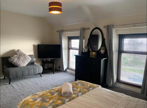 a bedroom with a bed and a mirror and a tv at 284 - Room 8 - Beachfront - Fantastic Sea views in Swansea