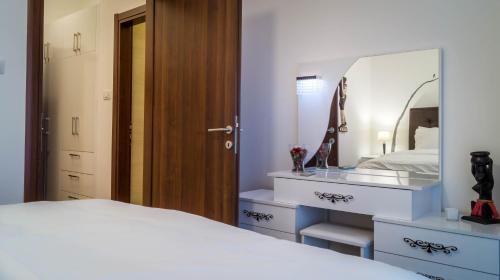 a bedroom with a white bed and a mirror at Luxury Budva Center Apartments in Budva