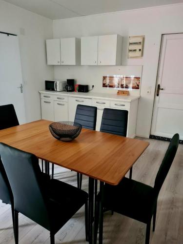 a kitchen with a wooden dining table and chairs at Chez Math in Stenay