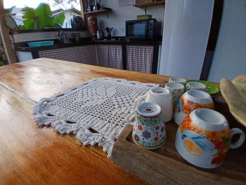 a wooden table with a group of cups on it at La Casita Casa Familiar Hospedagem e Camping Urbano in Navegantes