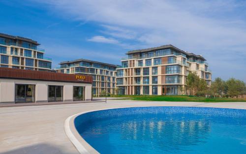 un hotel con piscina frente a un edificio en Beach House, en Nardaran