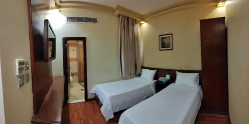 a hotel room with two beds and a mirror at Mira Ajyad Hotel in Makkah