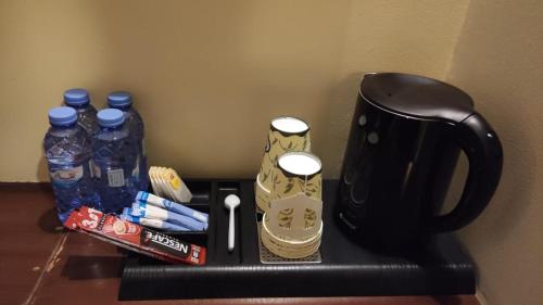a coffee maker with a remote control and bottles of water at Mira Ajyad Hotel in Makkah