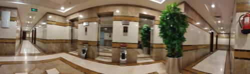 a lobby with two plants in a building at Mira Ajyad Hotel in Makkah