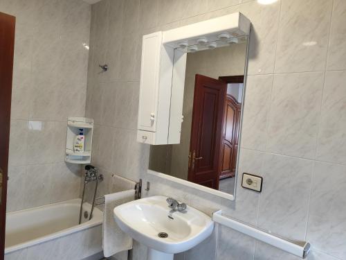 a bathroom with a sink and a mirror and a tub at Forxan in Sanxenxo