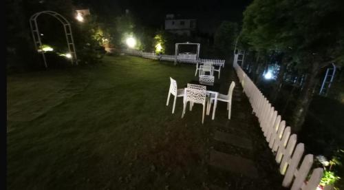 a group of chairs sitting in a yard at night at Orchard Valley View in Ooty