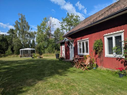 a red barn with a table and chairs next to it at Beautiful Idhult 2 in Aneby
