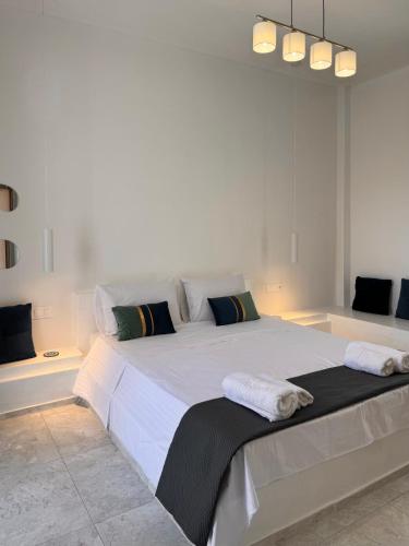 a bedroom with a large white bed with two pillows at AGAPI apartments in Kithnos