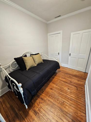 a bed in a room with a wooden floor at Baker Park Charm in Frederick