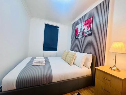 a small bedroom with a bed and a window at Stylish 1BR Flat Kings Cross, Central London in London