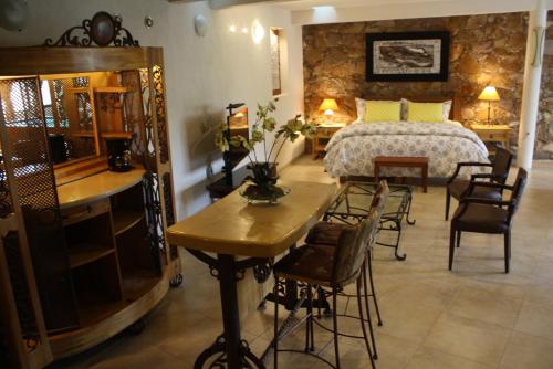 a bedroom with a bed and a table and chairs at Casa Corazon de Plata Suites in Guanajuato