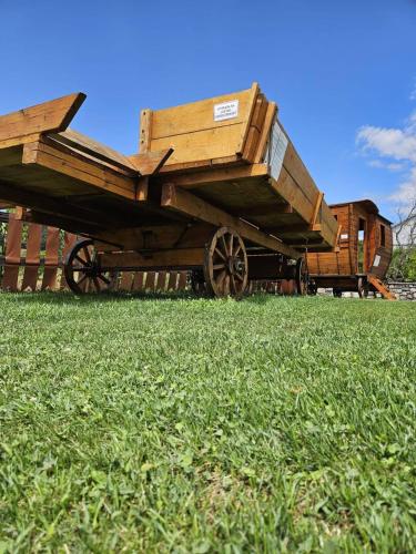 a wooden wagon sitting in a field of grass at Vinica Castle Boutique & Spa Hotel in Vinica