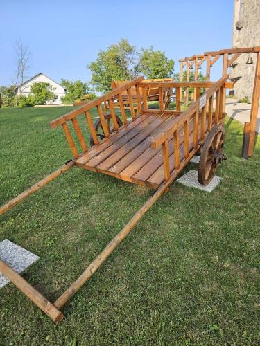 a wooden cart sitting on the grass in a field at Vinica Castle Boutique & Spa Hotel in Vinica