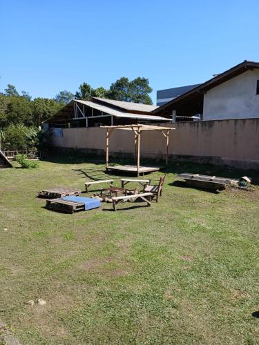 a picnic table and benches in a yard at La Casita Casa Familiar Hospedagem e Camping Urbano in Navegantes