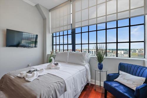 a bedroom with a large bed and a blue chair at XL Studio - Luxury Studio Near Center City in Philadelphia