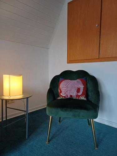 a green chair with a red pillow sitting next to a table at Vacation home Albersloh close to Münster in Sendenhorst